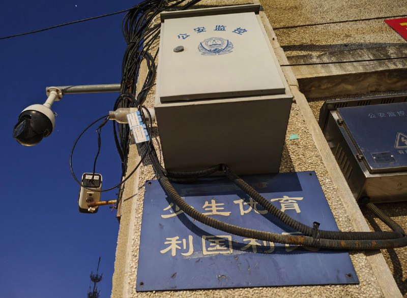 “无时无刻不在监控”网友投稿：在辽宁省大连市，一处计划生育时期遗留下来的标语“少生优育，利国利民”仍悬挂在墙面上，而标语正上方则安装着一台公安监控摄像头