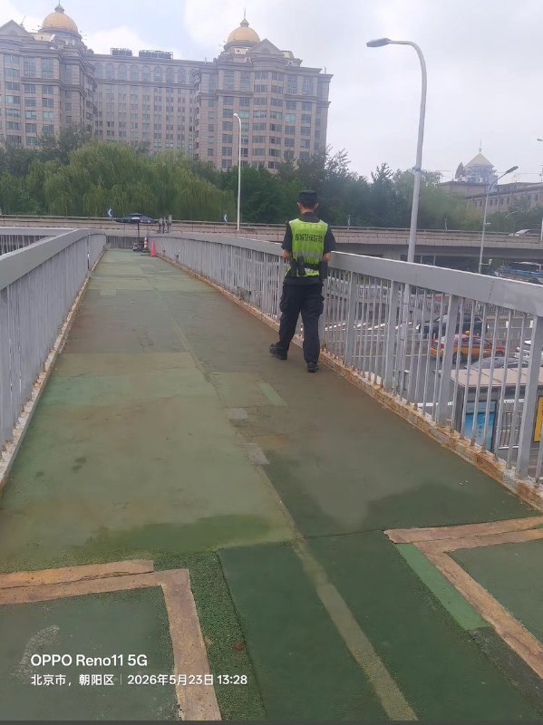 5月23日，网友拍到北京东二环励骏酒店旁边天桥上的守桥员