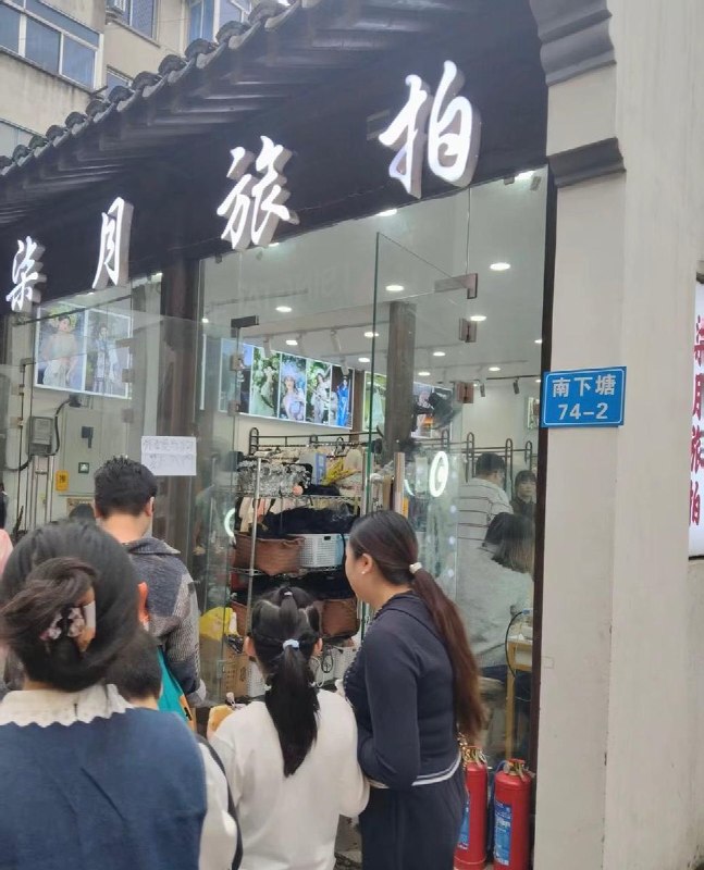 网友投稿:10月5日，江苏无锡，有网友拍到“柒月旅拍”门店门口张贴“外卖员与狗不得入”告示，引发部分外卖骑手不满，并在店铺附近聚集