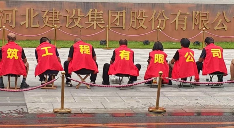 7月14日，河北，多名工人身穿印有“河北建设集团还我血汗钱”字样的马甲，敲锣打鼓聚集在河北建设集团股份有限公司门口维权