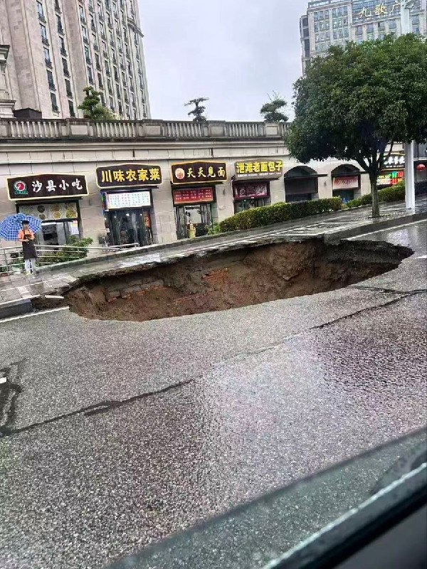 【湖北秭归洪水】 8月5日，湖北宜昌秭归县遭遇强降雨天气后，当地一处道路路面发生塌陷，出现一个大坑洞