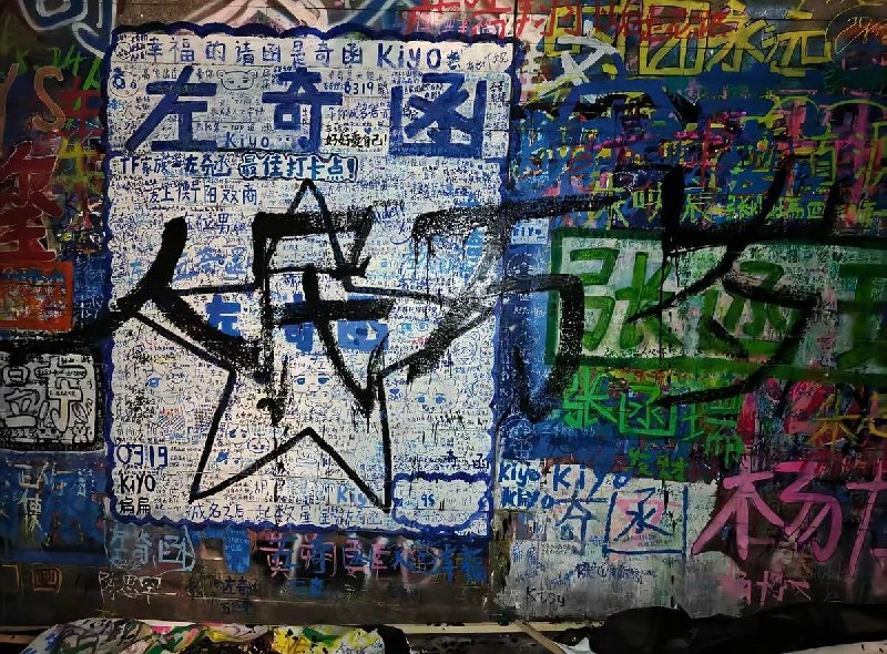 8月19日，重庆长江国际，粉丝聚集和打卡圣地——时代峰峻的涂鸦墙上，有人用黑色喷漆写下了大型的“人民万岁”字样，将原本写满偶像名字及追星留言的墙面大面积覆盖
