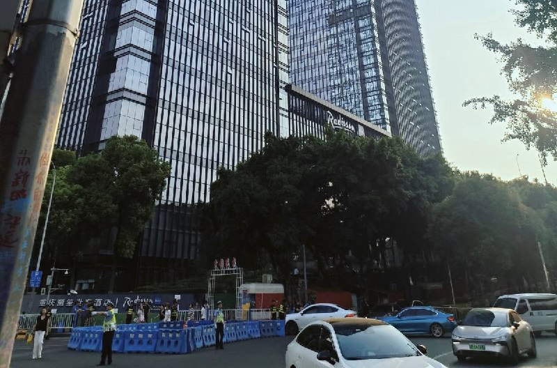 重庆时代峰峻抗议事件更新：8月20日，重庆南岸区长江国际，现场有大量公安及安保人员部署在道路两旁和写字楼周边拉起警戒线、劝离停留人员