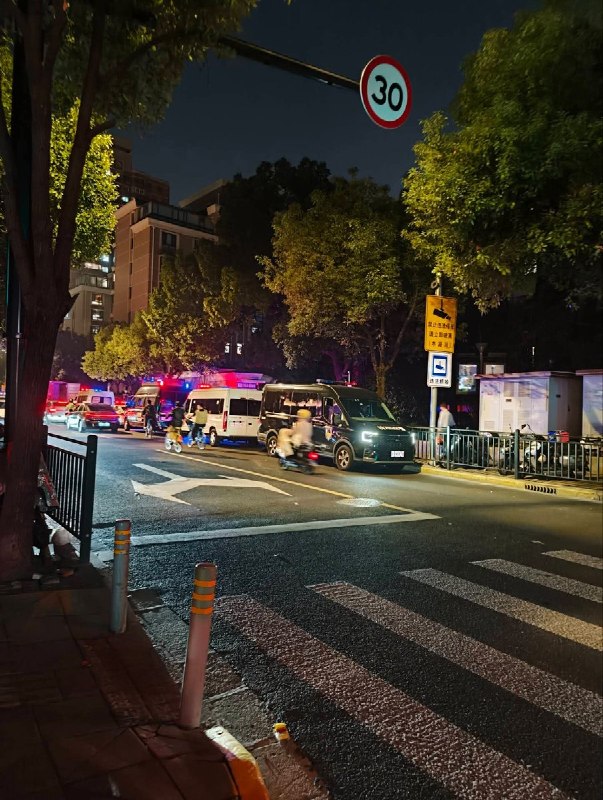 10月31日，上海万圣节街头，路边可见多辆亮着警灯的车辆