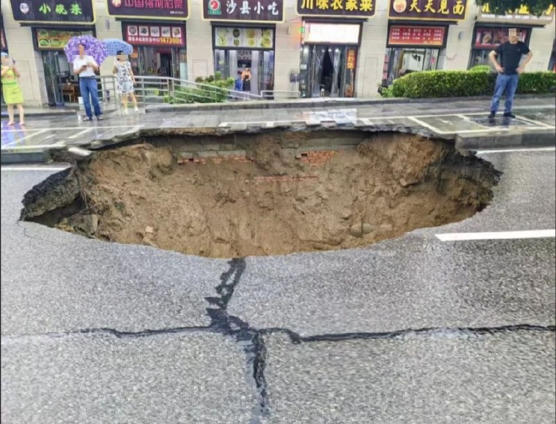【湖北秭归洪水】 8月5日，湖北宜昌秭归县遭遇强降雨天气后，当地一处道路路面发生塌陷，出现一个大坑洞