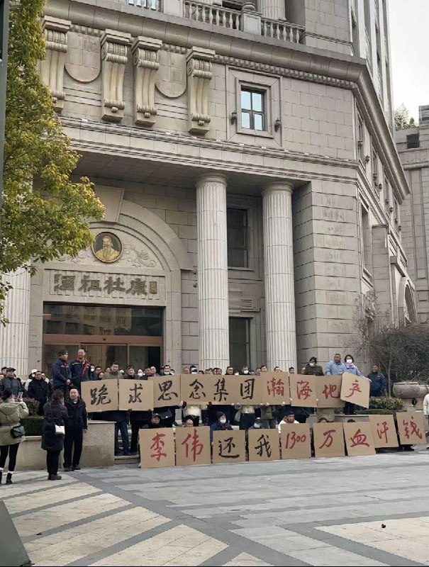 12月9日，河南省新郑市，郑州航空港经济综合实验区，一群人举着纸板写着：跪求思念集团瀚海地产李伟，还我1300万血汗钱