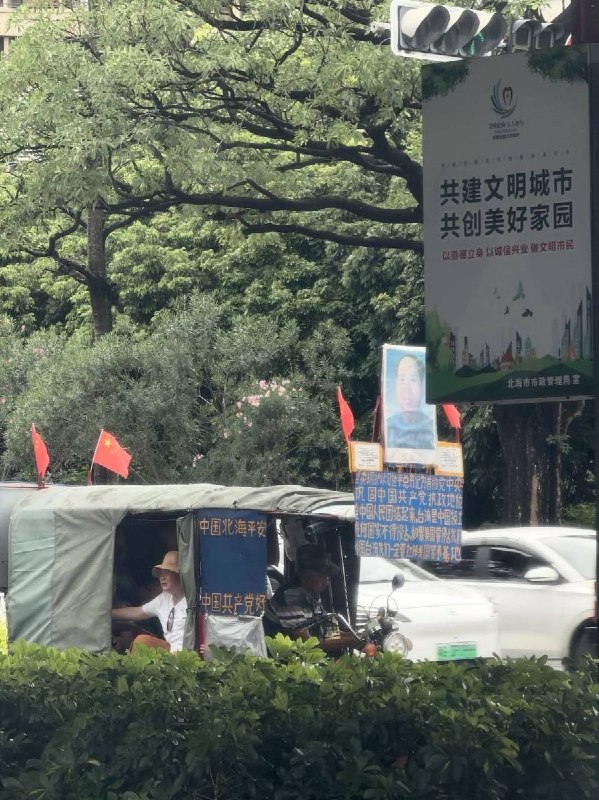 “毛习护体”北海三轮车大爷插国旗挂毛泽东像8月21日，广西北海一名拉客的三轮车大爷，在车上插着国旗、悬挂毛泽东肖像，并张贴“中国北海平安，中国共产党好”